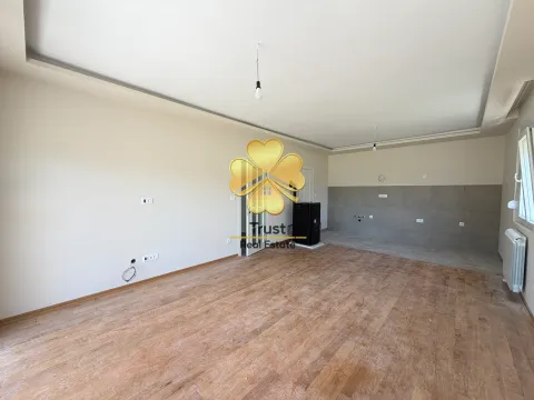 An empty room with hardwood flooring and tiles in the kitchen area. - image 4