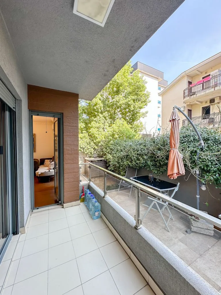 Spacious terrace with patio furniture and a view of greenery.