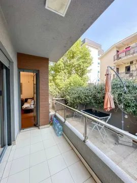 Spacious terrace with patio furniture and a view of greenery. - image 7