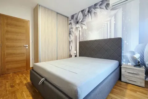 Furnished bedroom with a double bed, wardrobe, and feature wall wallpaper. - image 7