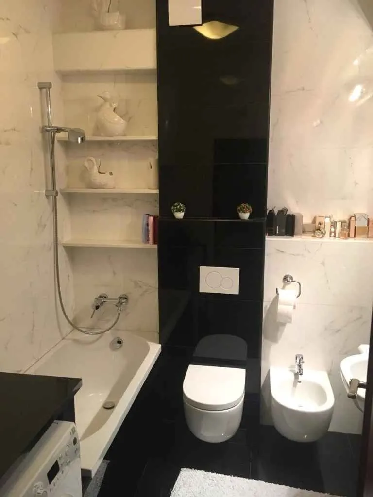 Moderno opremljeno kupatilo sa kadom, toaletom i ugradnim elementima.