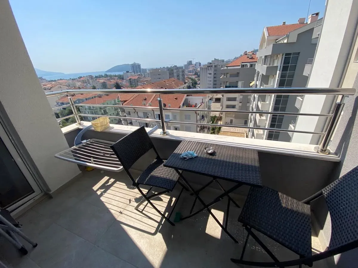 Namješten balkon sa garniturom za sjedenje i pogledom na grad i more.