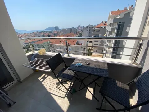 Namješten balkon sa garniturom za sjedenje i pogledom na grad i more. - image 6