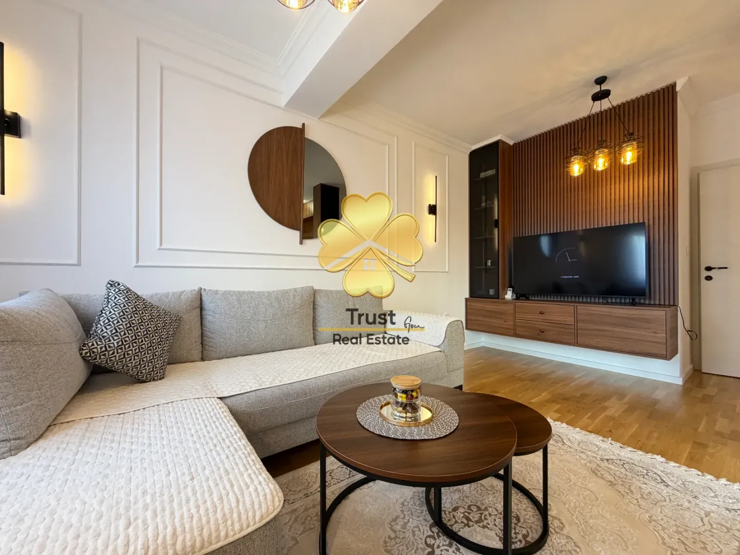 Modern and bright living room with a sectional sofa and wooden wall paneling.