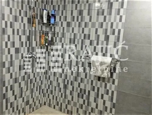 View of the shower cabin and wall tiles in the bathroom.