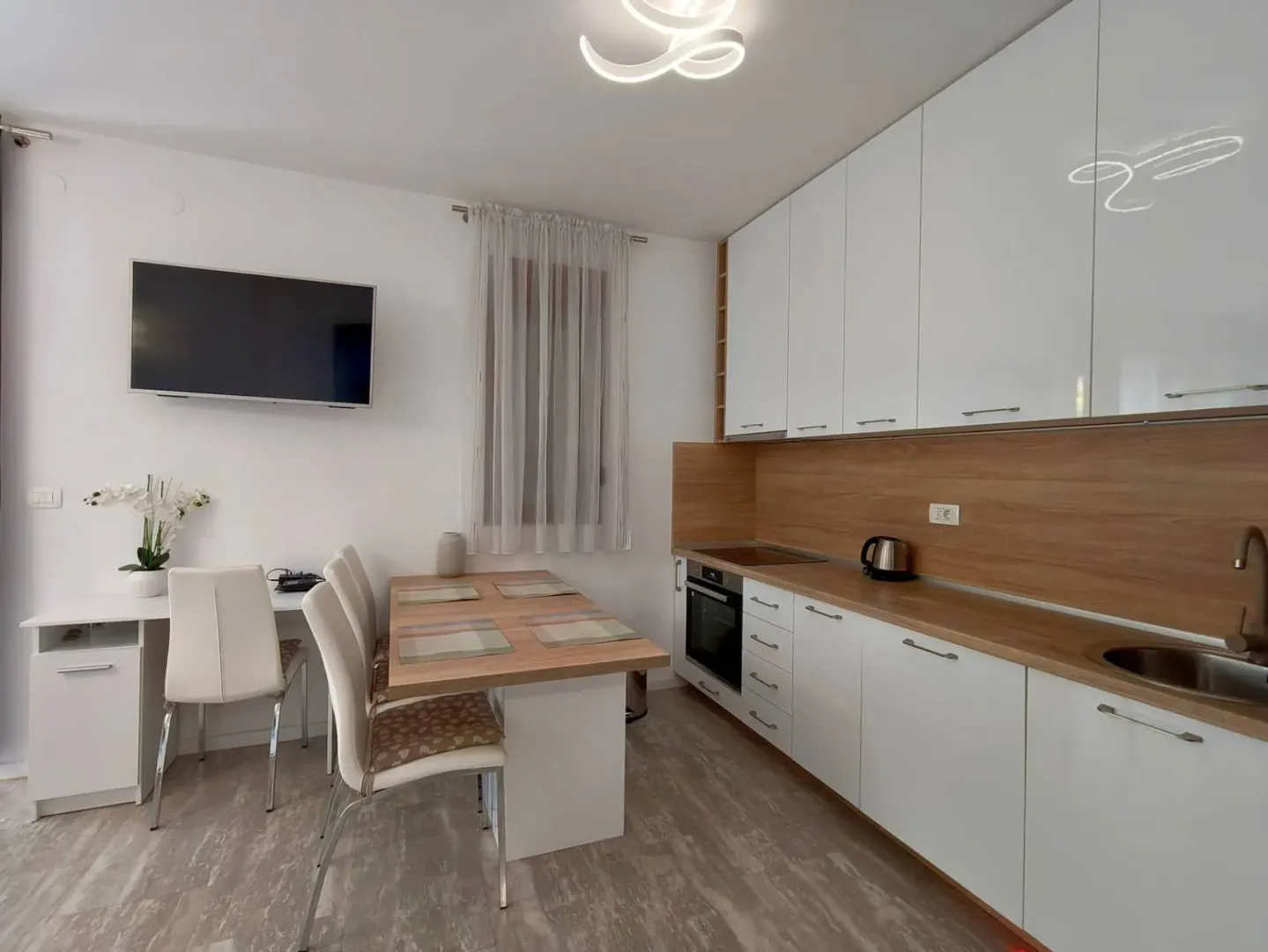 Modern kitchen with a dining table and white cabinetry.