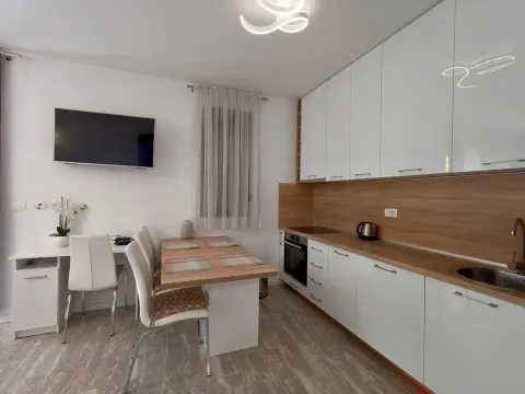 Modern kitchen with a dining table and white cabinetry. - image 5