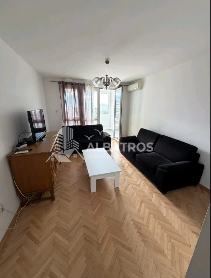Living room with a sofa set, TV cabinet, and access to the terrace.