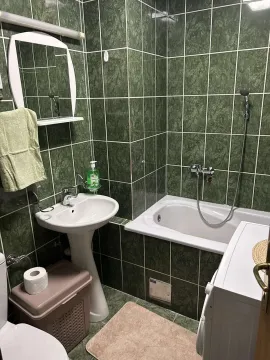 Kupatilo sa zelenim pločicama, kadom i umivaonikom. - image 17