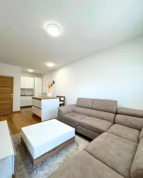 Dnevna soba sa garniturom, stočićem i pogledom na kuhinju u pozadini. - image 4