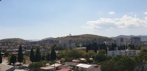 Panoramski pogled sa prozora na grad i brda u daljini. - image 18
