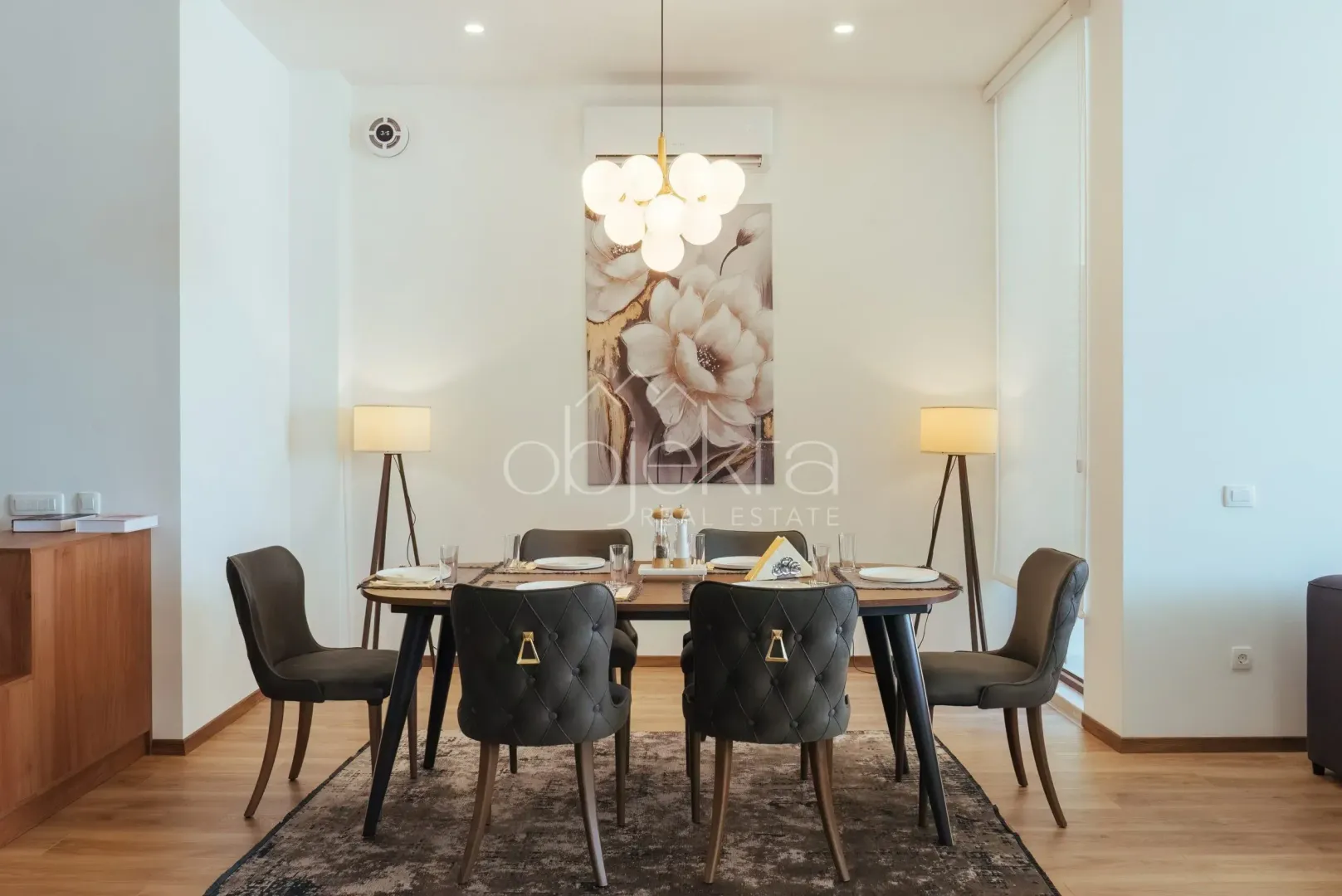 Dining area with a wooden table, chairs and a chandelier.