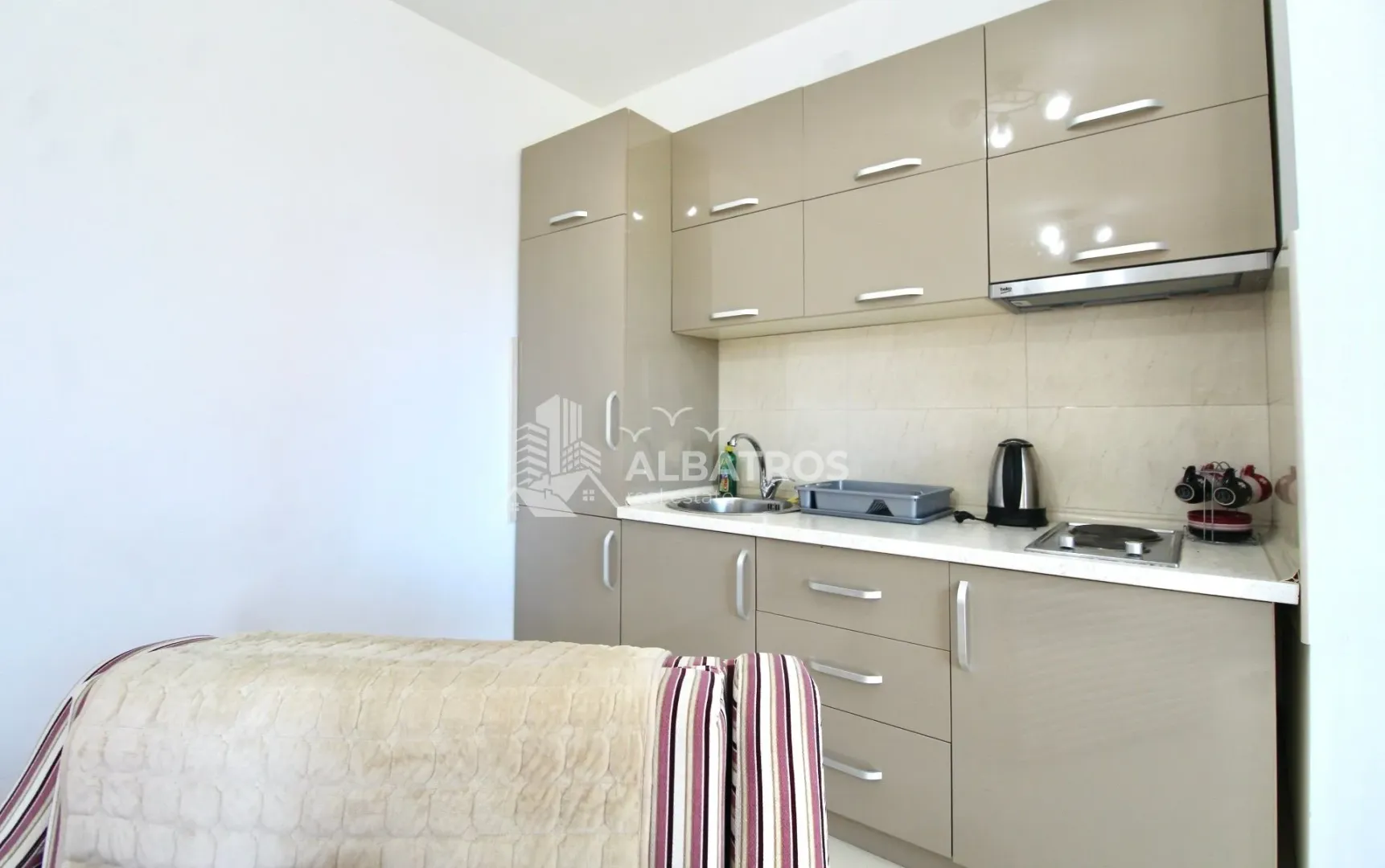 Small kitchen with beige cabinets and built-in sink.