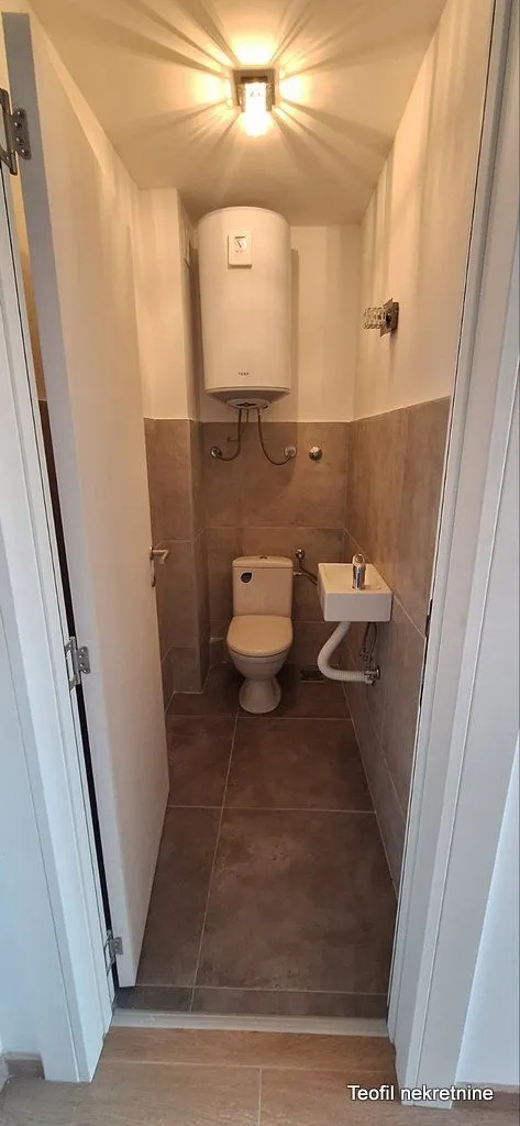 Manje kupatilo sa WC šoljom, umivaonikom i bojlerom.