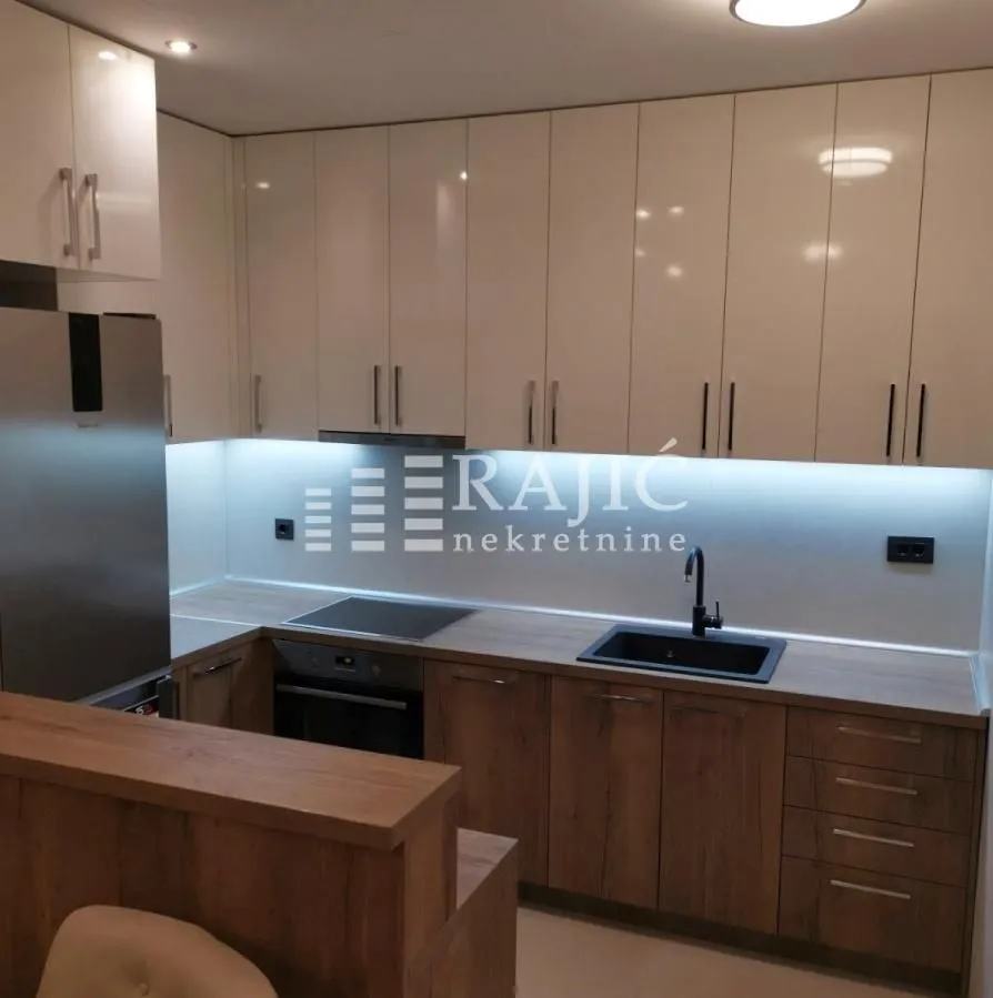 Modern kitchen with white and wooden cabinetry.