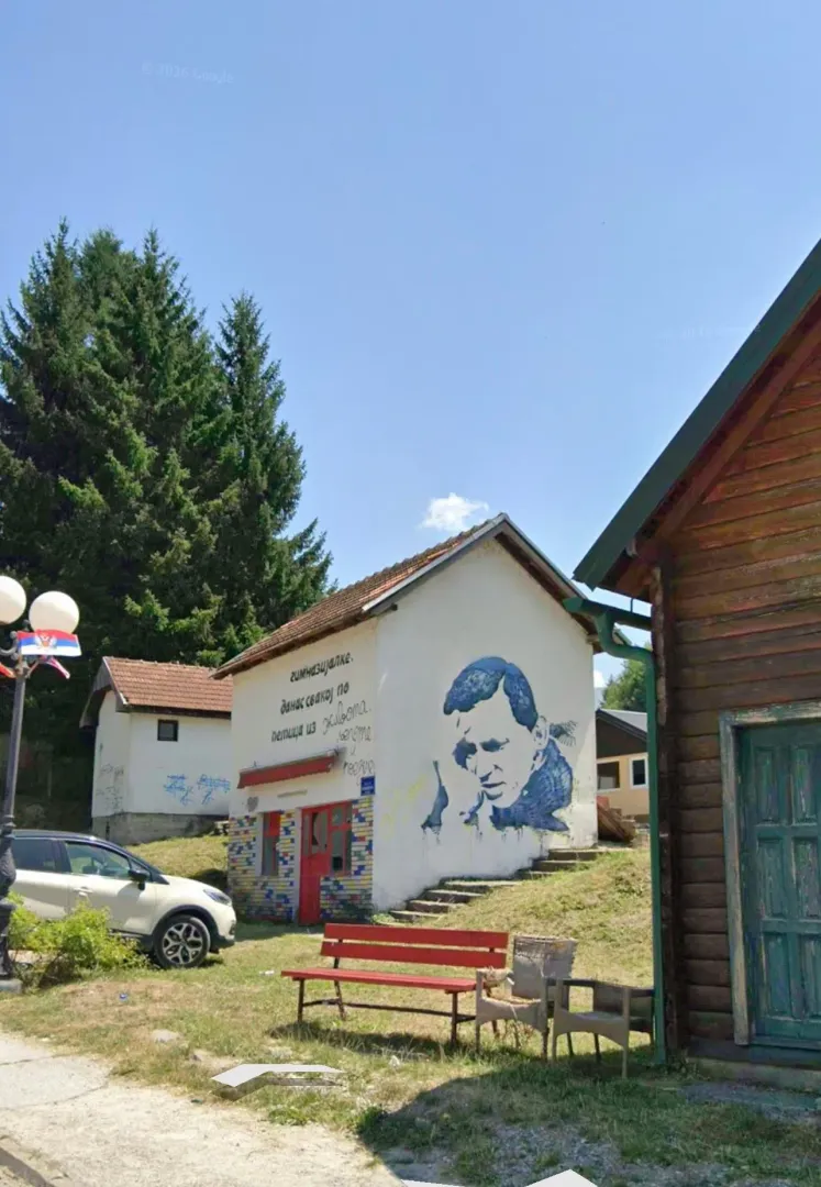 Exterior of a house with a yard and a mural on the wall.