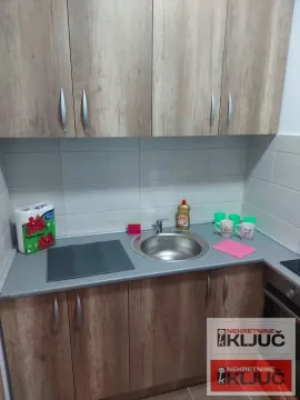 Manja kuhinja sa drvenim elementima, sudoperom i radnom površinom. - image 12