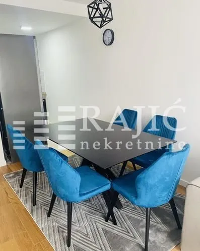Dining area with a black table and blue chairs.