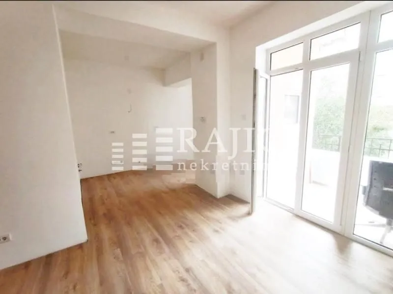 Empty room with laminate flooring and access to the terrace.
