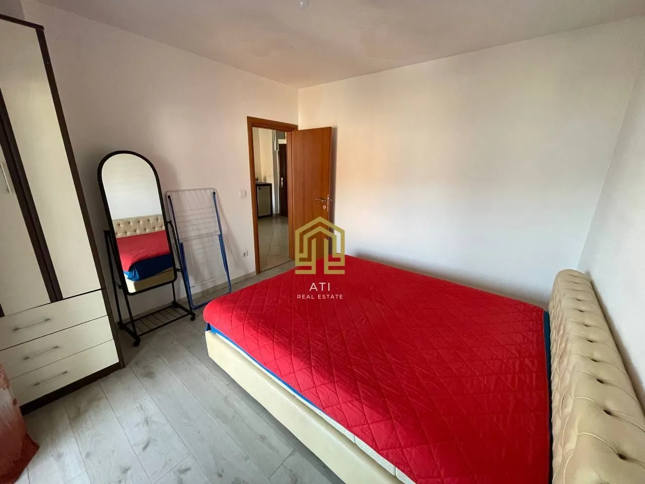 Furnished bedroom with a double bed, wardrobe, and mirror.