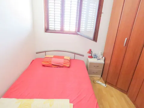 Manja spavaća soba sa krevetom, noćnim stočićem i drvenim ormarom. - image 6