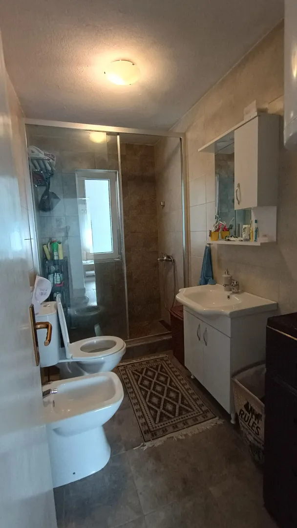 Kupatilo opremljeno umivaonikom, WC šoljom, bideom i tuš kabinom.