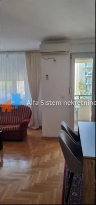 Dnevna soba sa garniturom za sedenje i trpezarijskim stolom.
