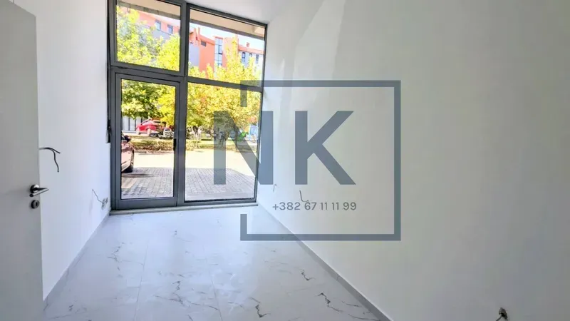 Empty room with a large glass storefront and white walls.