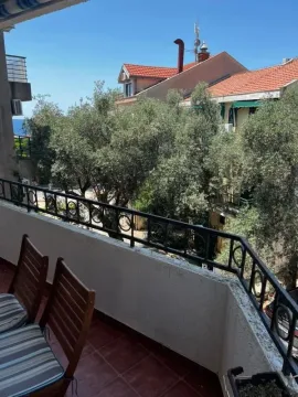 Balkon sa drvenim stolicama i pogledom na okolno zelenilo i susjedne kuće. - image 5