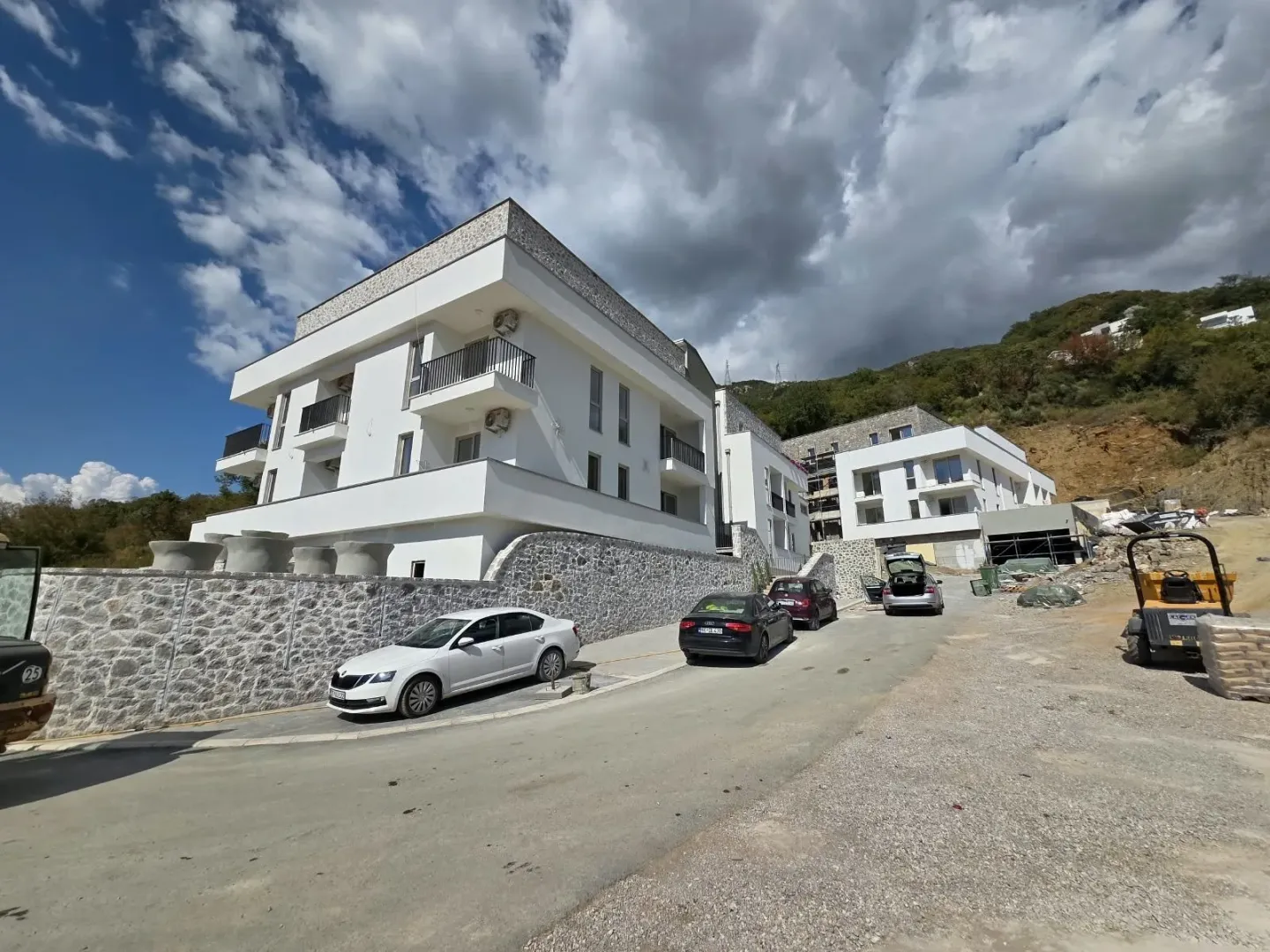 Exterior view of modern residential buildings with a parking area and driveway.
