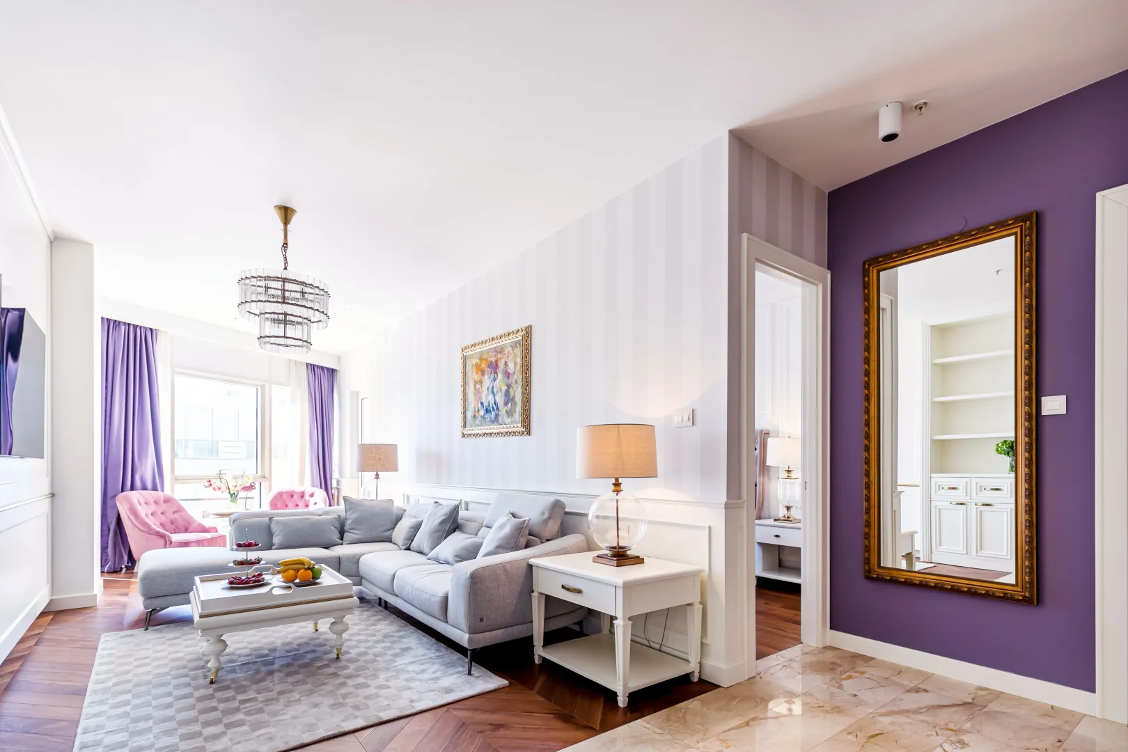 Spacious and bright living room with a sofa, coffee table, and a view into the hallway.