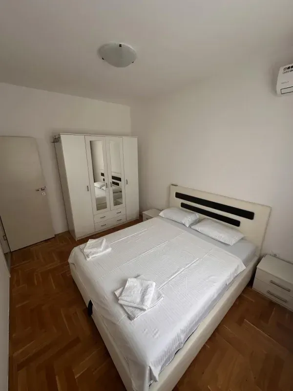 Furnished bedroom with a double bed and a wardrobe.