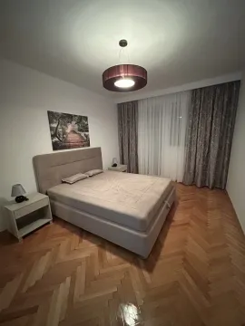 A bright bedroom with a double bed, nightstands, and parquet flooring. - image 7