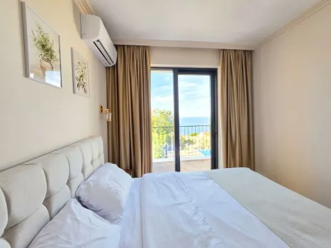 Bedroom with a double bed and access to a terrace with a sea view. - image 11