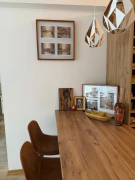 Dining area with a wooden table, chairs, and decorative items. - image 14