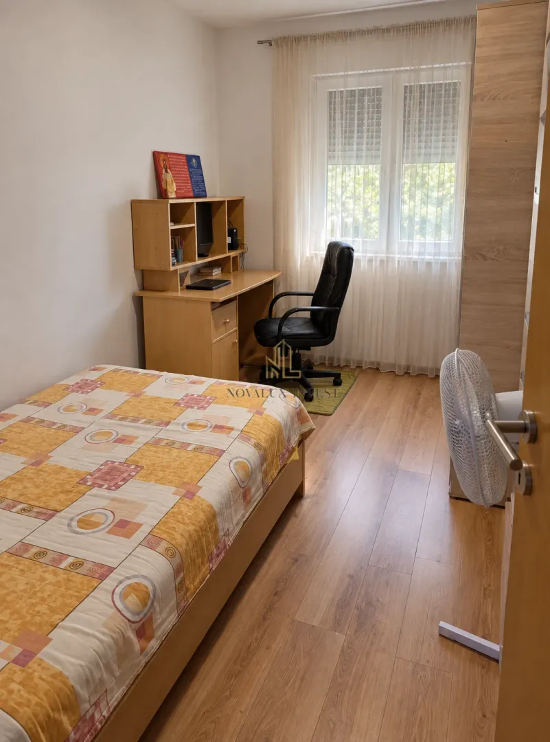 Manja spavaća soba sa krevetom, radnim stolom i plakarom.
