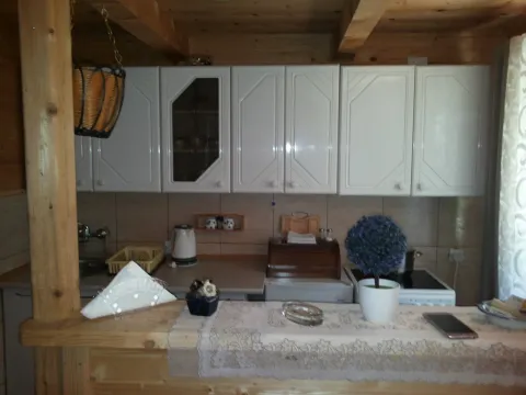 Kuhinja sa bijelim elementima i drvenim detaljima u kući. - image 9