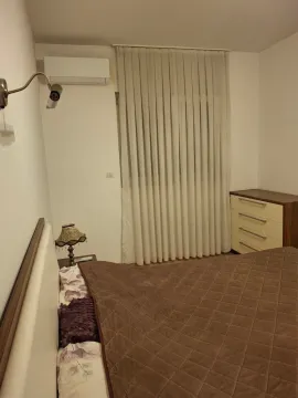 Furnished bedroom with a double bed, dresser, and air conditioning unit. - image 14
