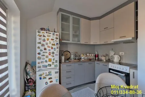 Small kitchen with grey and beige cabinets and a refrigerator covered in magnets. - image 17