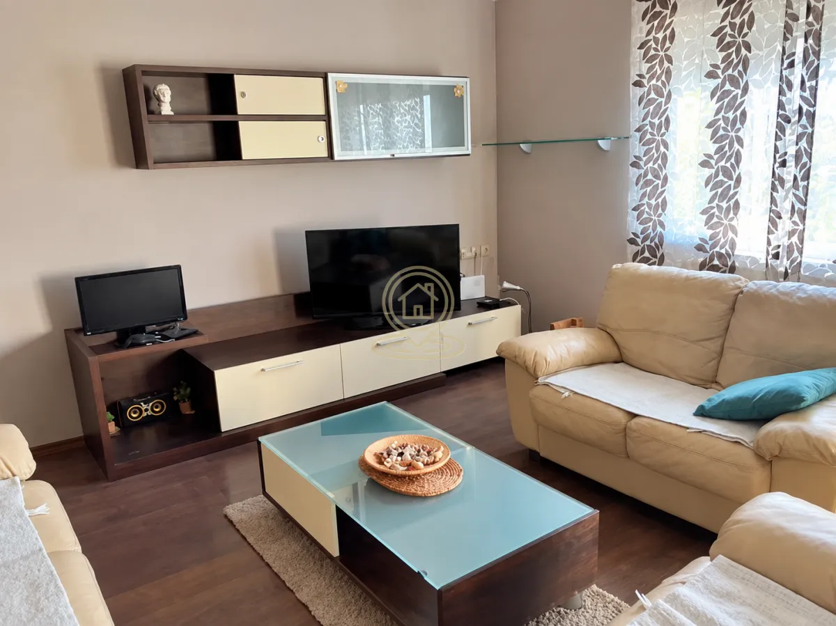 Dnevna soba sa garniturom, TV komodom i stočićem.