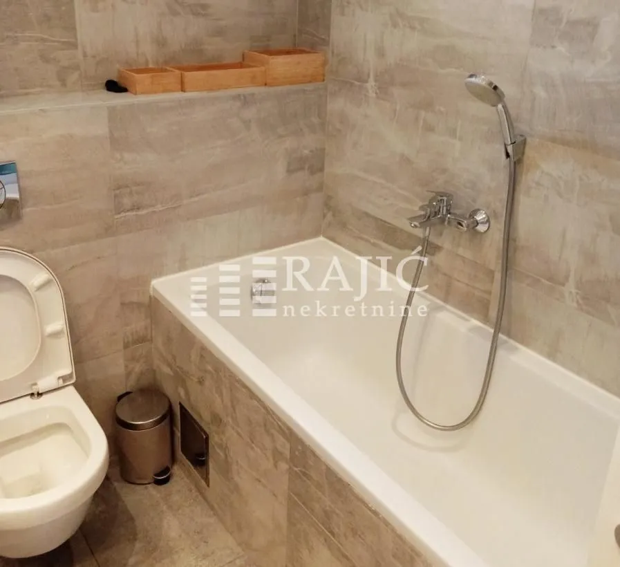 Modern bathroom with a bathtub and toilet.