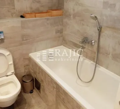 Modern bathroom with a bathtub and toilet. - image 13