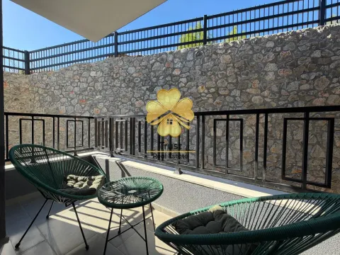 Small terrace with seating furniture and a stone wall in the background. - image 7