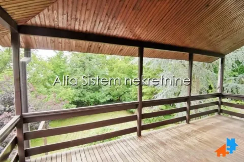 Wooden covered terrace with a view of the yard and greenery. - image 13