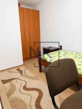 Manja spavaća soba sa krevetom, drvenim ormarom i stazom na podu. - image 4