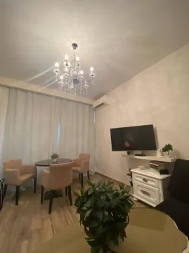Dnevni boravak sa garniturom, TV-om i trpezarijskim stolom sa stolicama. - image 2