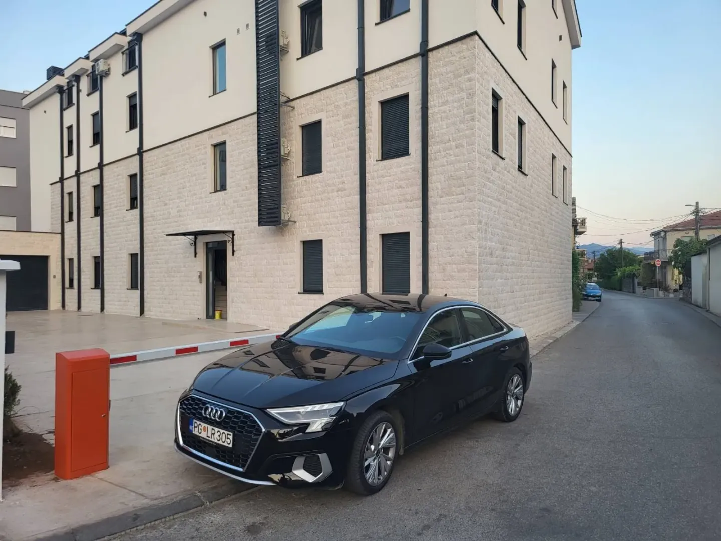Exterior of a modern residential building with parking in front.