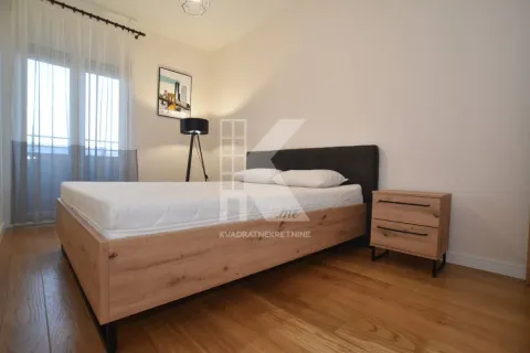 Spavaća soba sa bračnim krevetom, noćnim stočićem i prozorom sa zavjesama. - image 5