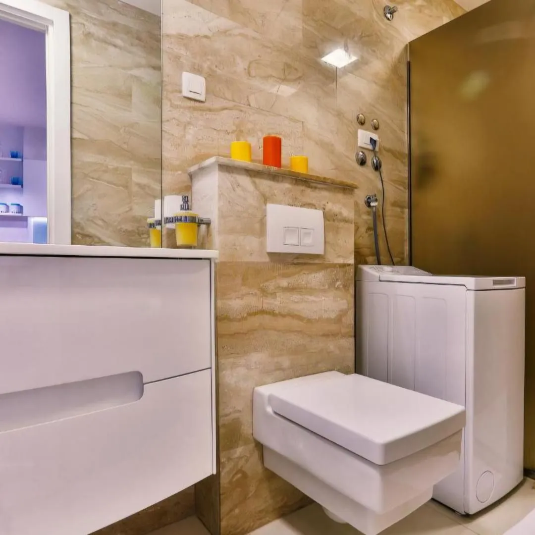 Modern bathroom with white sanitary ware and beige ceramic tiles.
