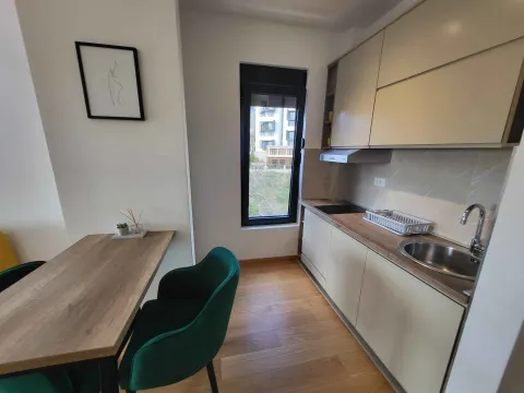 Moderna kuhinja sa trpezarijskim stolom i zelenim stolicama. - image 7